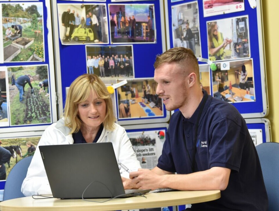 woman and young man sat at a laptop